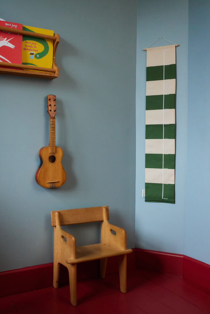 Green striped growth chart for children in a blue and red room
