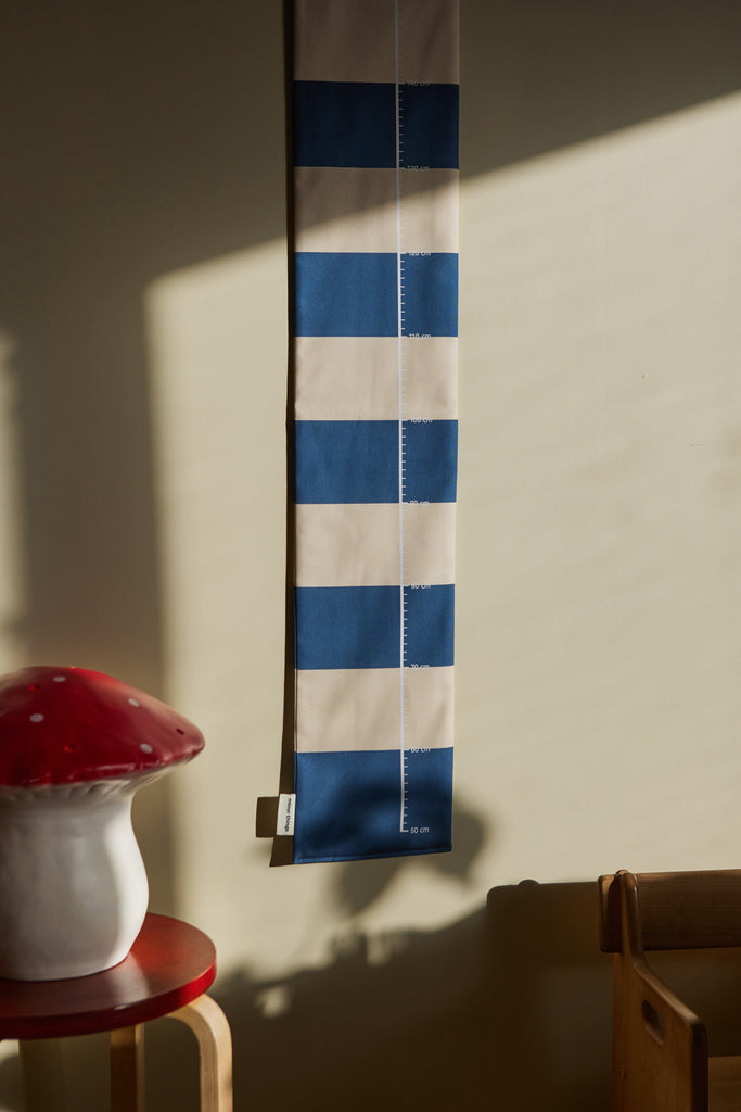 Blue striped growth chart for children and a night lamp