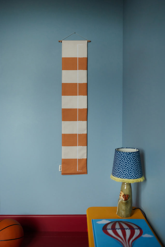 Orange striped growth chart for children in a blue and red room