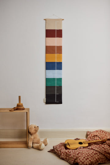 Colorful striped growth chart for children and daisy printed bedding