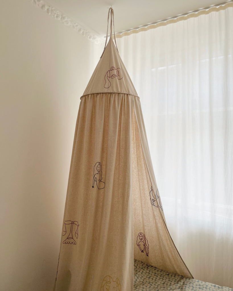 Sand colored bed canopy with handwoven zodiac signs