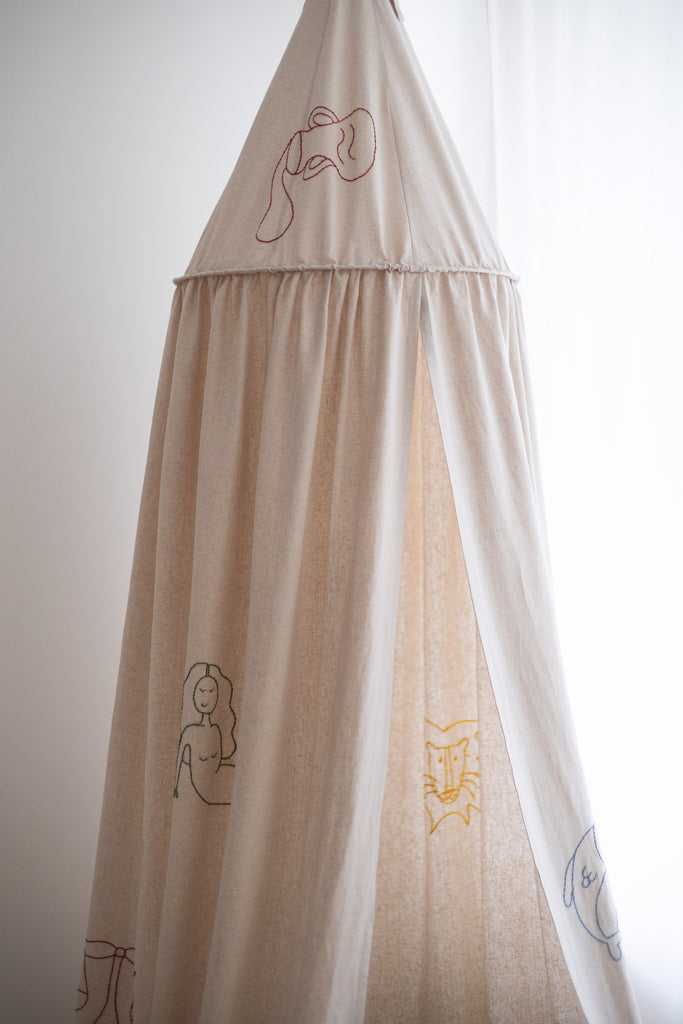 Sand colored bed canopy with handwoven zodiac signs