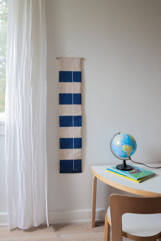 Blue striped growth chart for children besides a table