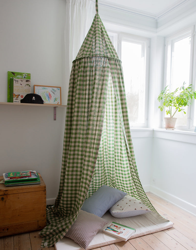 Green Bed Canopy with gingham fabric used as a reading nook